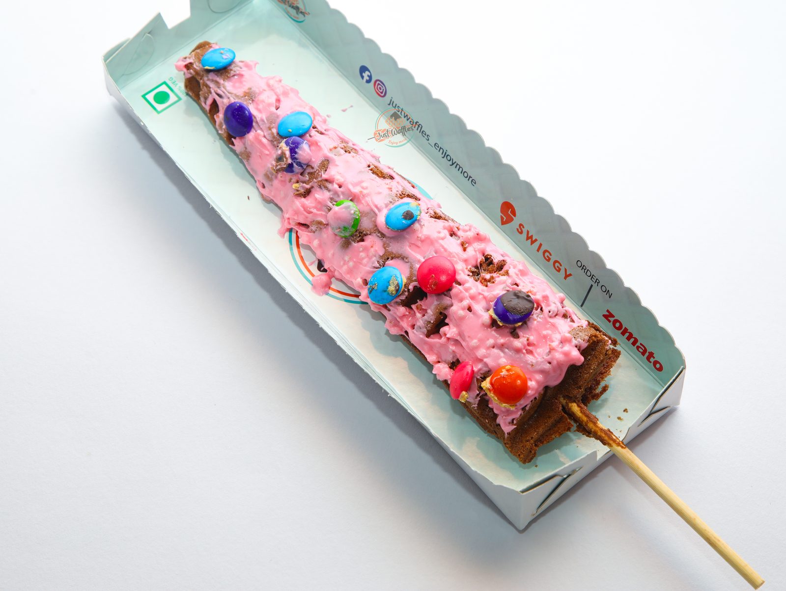 Artisanal chocolate sauce cascading over warm waffle grids